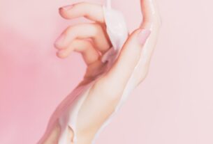 a woman's hand holding a bottle of lotion