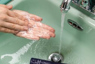 person washing hands on sink