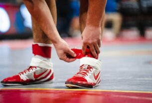 a close up of a basketball player tying his shoes