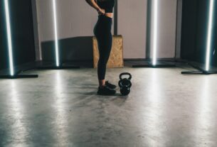 woman in black tank top and black leggings standing on white floor